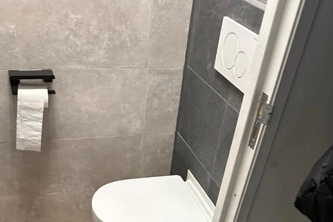 Hangend toilet en tegelwerk in een toiletgroep van Refix